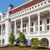 Pinx's Hostel in Jakarta, white colonial-style hotel facade with columns and red roof