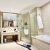 Grand Metropark Hotel Shangqiu bathroom with glass shower, soaking tub, vanity and toilet