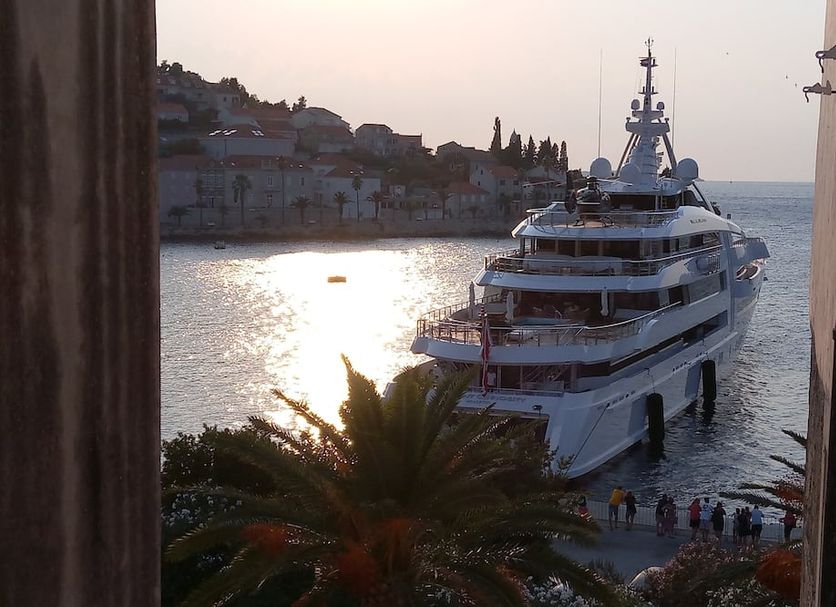 Accommodation Old Town Vitaic in Korčula with a large yacht in the harbor at sunset and waterfront views