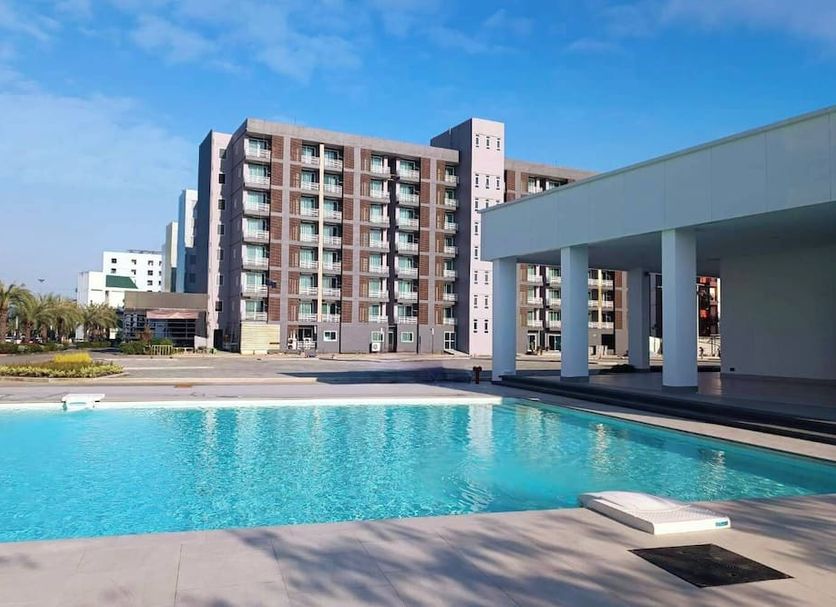 Tm Land Hotel in Ayutthaya with outdoor pool and modern hotel buildings under a clear sky