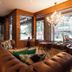 Hotel Cercano in Gramado lounge with tufted sofa, chandelier, and large street-facing windows