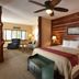 Stoney Creek Hotel Sioux City guest room with king bed, wood-paneled accent wall, and sitting area