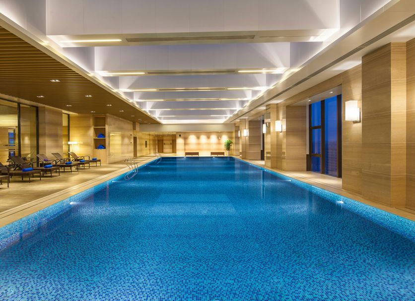 Somerset Xindicheng Xi'an indoor lap pool in Xi'an with blue-lit water and lounge seating