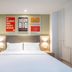 Hanting Hotel Qingdao Taidong Pedestrian Street room with bed, desk and wall art in Qingdao