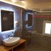 Hospitality Hotel Palermo bathroom with sink, mirrors, shower, and small window