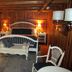 Chalet of Canandaigua guest room with white bed, loveseat, and wood-paneled cabin interior
