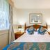 Twin Towers Inn in Artarmon guest room with twin beds, bedside lamps and window curtains