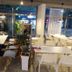 Pohang Youngildae Guesthouse café seating area with tables, chairs and street-facing windows in Pohang
