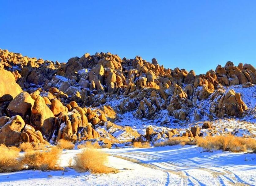 Mount Whitney Motel in Lone Pine with snow-covered desert rocks under a clear blue sky