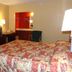 Executive Inn Rocky Top guest room with bed, TV, lamps, desk, and vanity