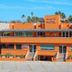 Hotel Boutique Plaza Doradas in San José del Cabo, orange 3-story hotel exterior with rooftop palms