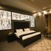 Safir Hotel Dushanbe guest room with king bed, decorative wall panels, seating area and curtain-covered window