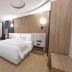 Arabella Residence Cairo guest room with king bed, wood-paneled wall, desk, and curved ceiling design