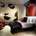 Hard Rock Hotel & Casino Biloxi guest room with king bed, red chair and modern wall art