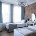 Luna Boutique Hotel Antalya guest room with twin beds, brick accent wall, vanity, and large windows