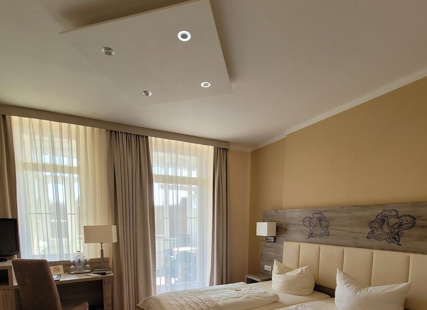 Hotel Rosengarten Bad Salzuflen guest room with double bed, desk and large windows