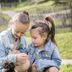 Family Resort Rainer Sexten in Sesto: two children in denim jackets petting a small rabbit outdoors