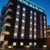 Hotel Route-Inn Saku Minami Inter in Saku at dusk, exterior view with illuminated sign and balconies