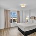 The Avalon Club in Clearwater Beach bedroom with window view, king bed and bedside lamps