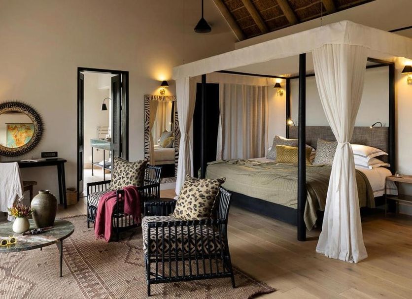 Monwana Game Lodge, Hoedspruit: stylish suite with four-poster bed, sitting area and high thatched ceiling