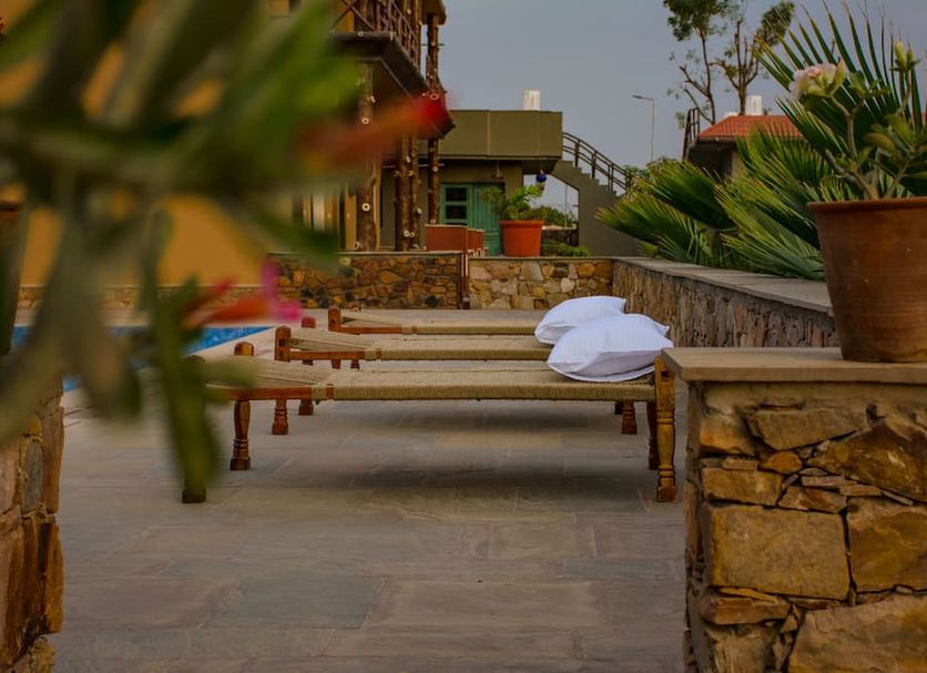 Hathi Mauja in Jaipur with outdoor loungers, potted plants and stone terrace seating area