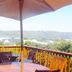 Knysna Manor House terrace with table, umbrella, wooden chairs and views over Knysna lagoon