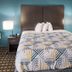 Motel 6 Crowley, La guest room with king bed, teal walls and bedside lamps