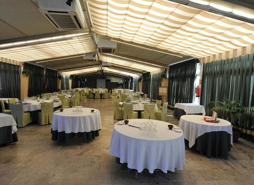 Hotel Puerta de Segovia in Segovia banquet hall with round tables and striped ceiling canopy