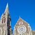Haka Lodge Christchurch exterior with a tall stone church spire against a blue sky