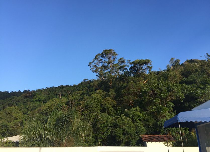 The Hyperion Boutique Hotel in Florianopolis with hillside greenery under a clear blue sky
