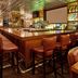 The Lincoln Marriott Cornhusker Hotel bar with long wooden counter, leather stools, and mirrored back bar in Lincoln