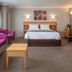 Best Western Heath Court Hotel, Newmarket room with bed, magenta sofa, desk, and window seating
