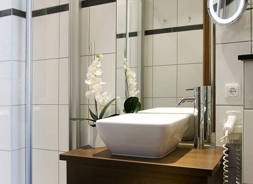 Boutique-Hotel Moseltor bathroom with vessel sink, orchid, and tiled shower in Traben-Trarbach