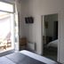 Hôtel En Ville in Aix-en-Provence with open balcony doors, wall TV, and a view into the bedroom