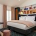 Hotel Louvre Montana Paris guest room with king bed, desk, chair and floor-to-ceiling windows