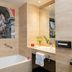 Leonardo Hotel Madrid City Center bathroom with bathtub, glass shower, and city artwork in Madrid
