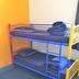 Abel's Central Backpackers in Nelson, bunk beds with blue frames and gray bedding in a hostel room