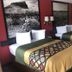 Super 8 Corsicana guest room with two double beds and landscape wall art
