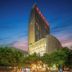 Redstar Culture Hotel in Hangzhou with illuminated high-rise exterior at dusk, surrounded by trees