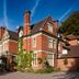 The Coed-Y-Mwstwr Hotel in Bridgend, red-brick country house exterior under blue sky