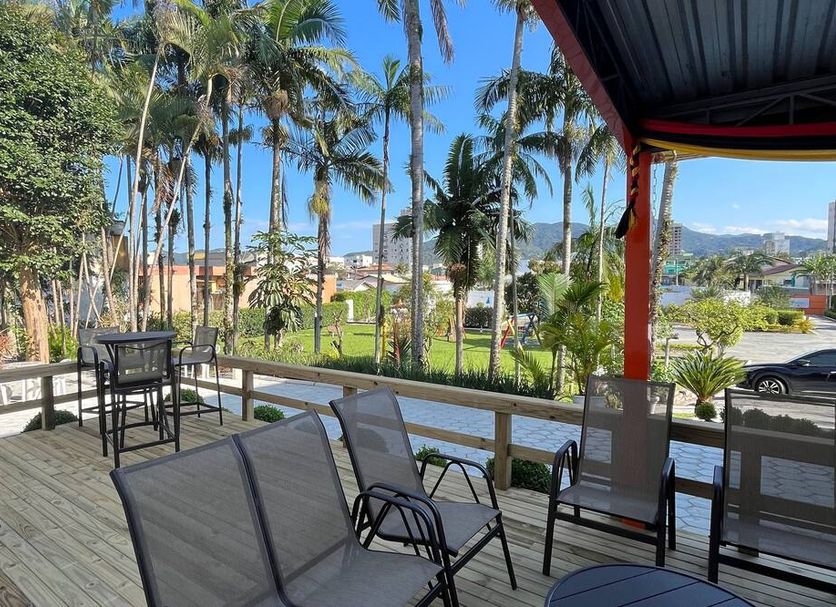 Hotel Arco Do Sol in Balneário Camboriú with palm-lined outdoor seating and a city view