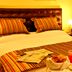 Oporto Hotel Boutique in Santiago guest room with striped bed linens, bedside lamp, and breakfast tray
