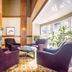 Glacier Lodge in Whistler lounge with purple armchairs, stone fireplace and large windows