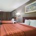 Americas Best Value Inn Tulsa at I-44 guest room with two beds, TV, and red door in Tulsa