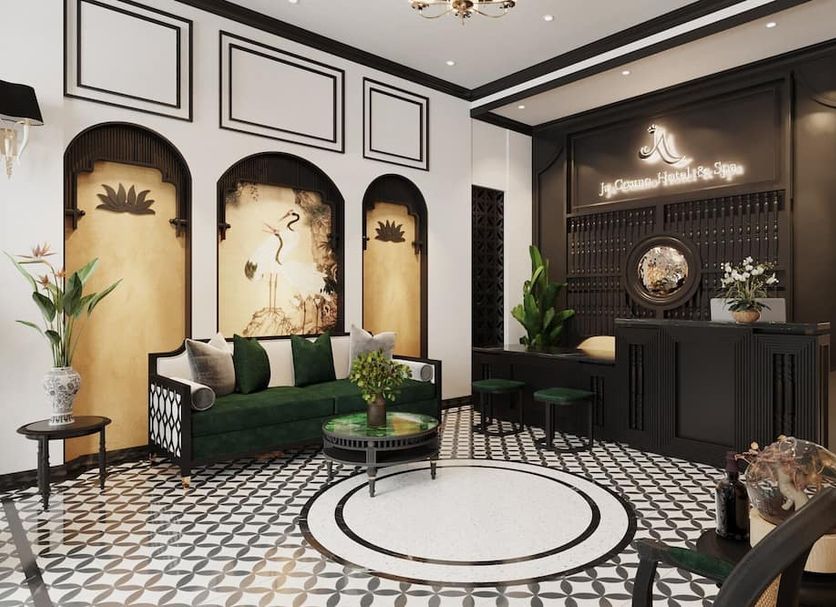 Ja Cosmo Hotel and Spa in Hanoi lobby with green sofa, patterned floor, and black front desk