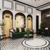 Ja Cosmo Hotel and Spa in Hanoi lobby with green sofa, patterned floor, and black front desk