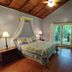 Mckinley Edwards Inn Bryson City bedroom with king bed, wood ceiling, and balcony doors