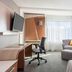 Courtyard by Marriott London guest room with sofa, desk, chair and TV near a window