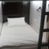 Vintage Inn Boutique Capsule @ Little India, Singapore capsule bed with white linens and hanging clothes