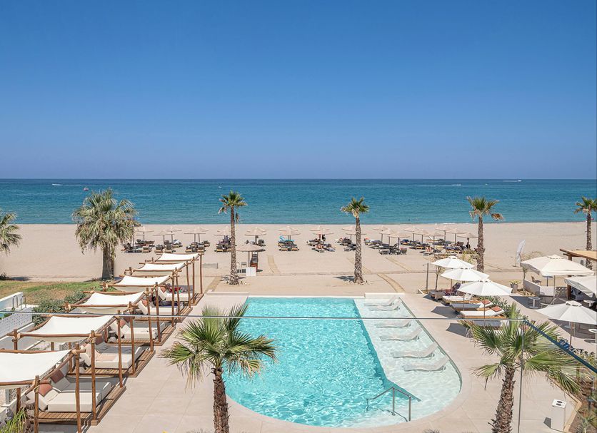Iperion Beach Hotel, Rethymno: beachfront pool with loungers, cabanas, palm trees and sea view
